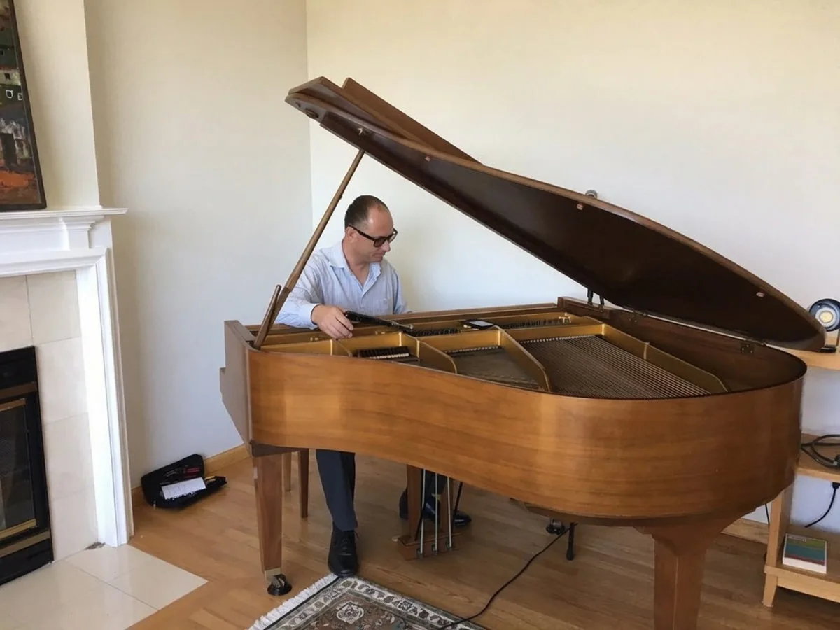Thomas Penders tuning a grand piano at a student home in Petaluma, CA